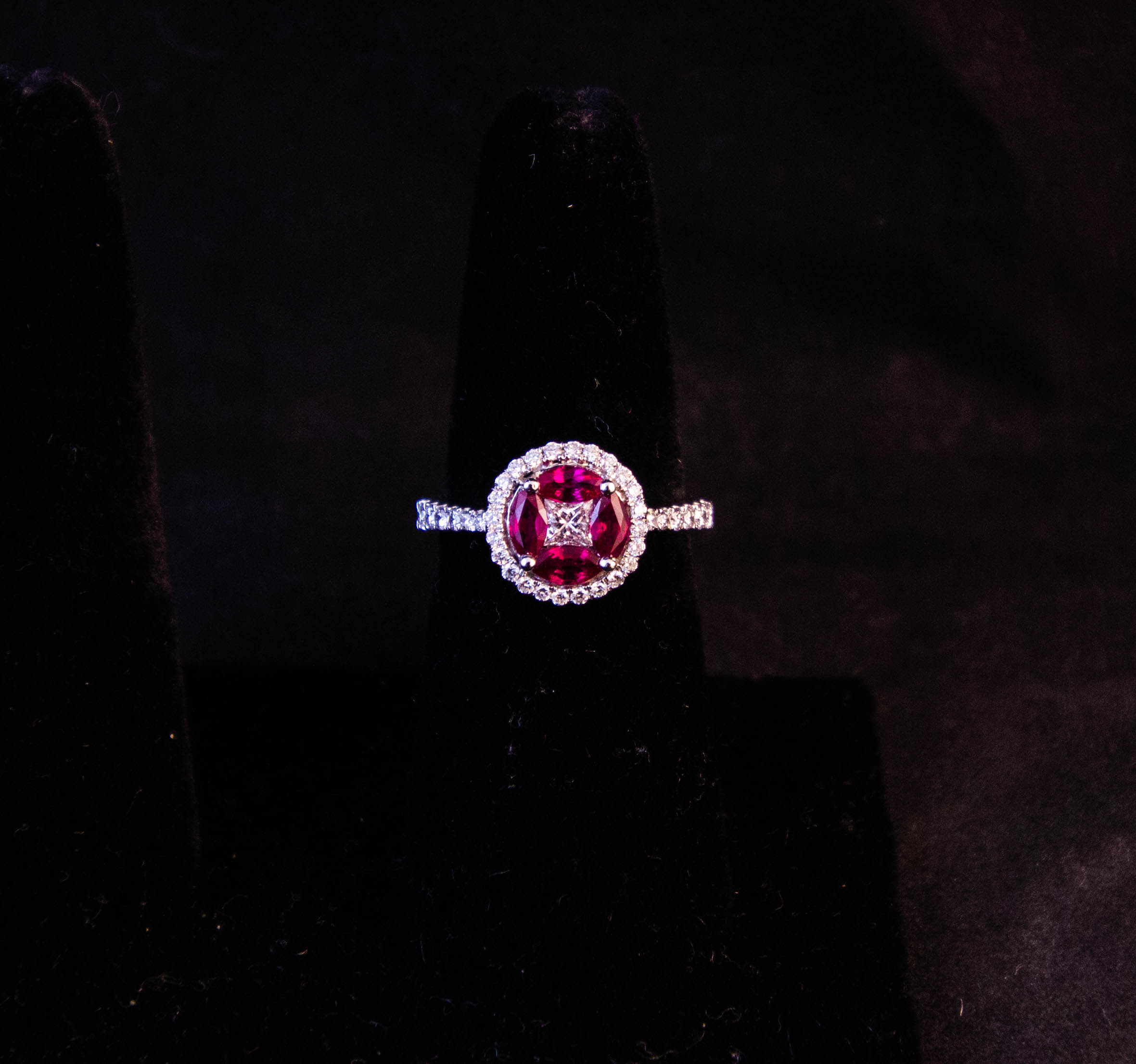 IMG_0712 18k white gold pave diamond and ruby ring. Four marquis cut rubies surround a princess cut diamond, with surrounding diamond halo and diamond shoulders on the band. Total ruby content .8ct, centre princess diamond .2ct, and diamond content of halo and shoulders is .35ct. Price includes nationwide delivery.